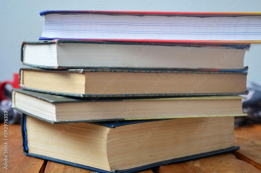 Naklejka premium A stack of old books with yellowed pages, textbook, training, encyclopedia. Reading, knowledge. Library.