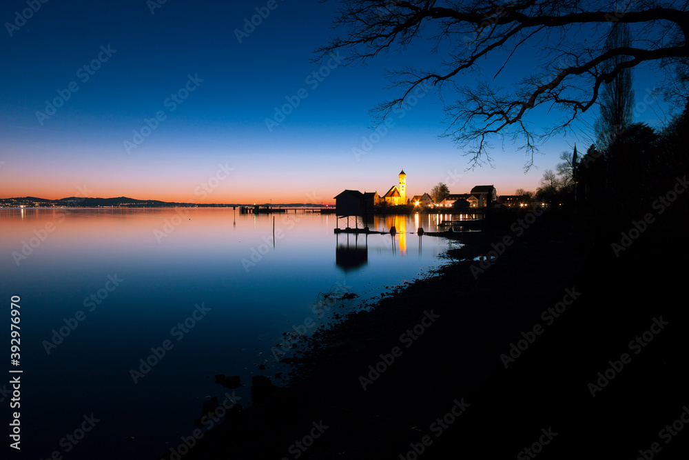 Sonnenuntergang am Bodensee mit Kirche im Hintergrund