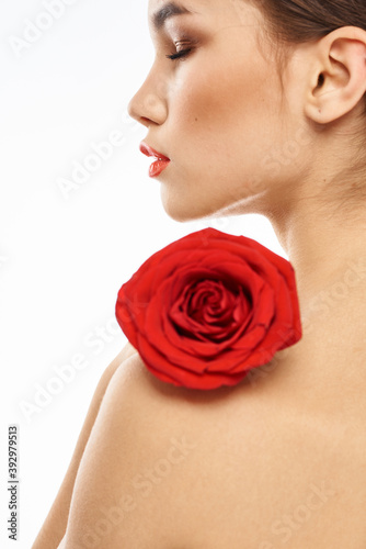 Portrait of woman with red rose naked shoulders Make-up on brunette face