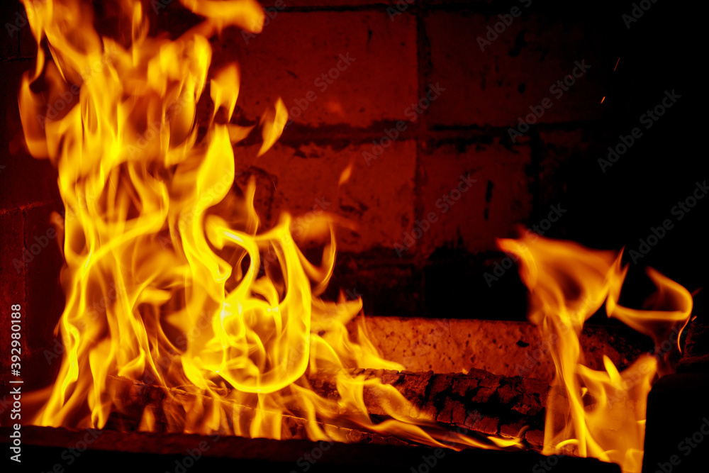 Obraz premium Yellow flames in the fire with wood and log.