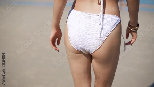 Beautiful woman butt walking at the sea
