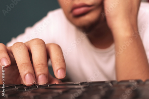 Lazy tired man hands typing on keyboard, browsing internet on pc computer © airdone