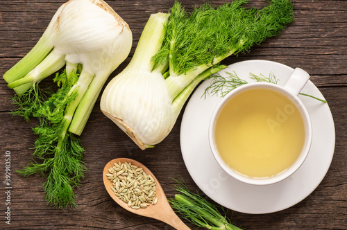 Herbal infusion fennel tea in glass cup or mug with dried fennel seeds and fennel bulbs. Alternative medicine background concept (Foeniculum vulgare)