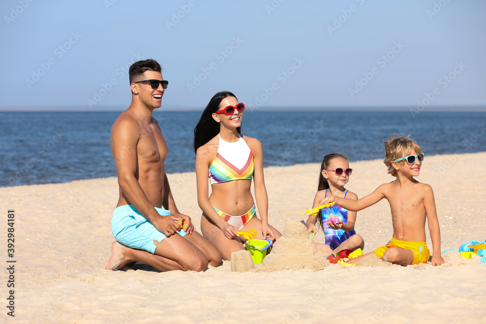 Happy family playing on sandy beach near sea. Summer holidays Happy family playing on sandy beach near sea. Summer holidays