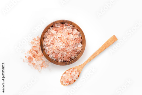 Himalaya pink salt in wooden bowl and spoon on white background. photo