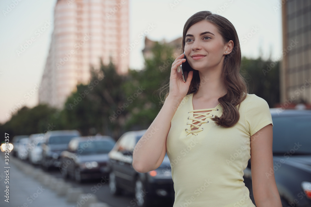 Beautiful young woman talking on phone outdoors Beautiful young woman talking on phone outdoors