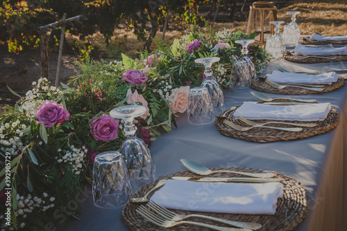 party table in the middle of a vineyard with golden cutlery