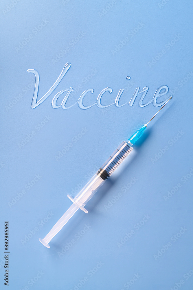 Liquid inscription Vaccine and a syringe on a blue background Liquid inscription Vaccine and a syringe on a blue background