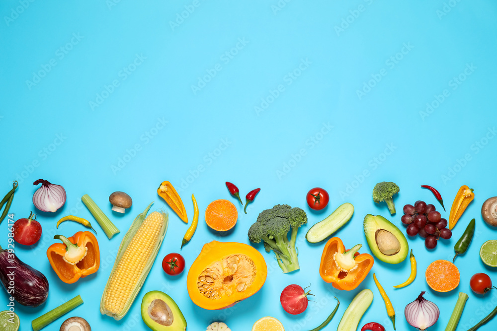 Flat lay composition with fresh organic fruits and vegetables on light blue background. Space for text