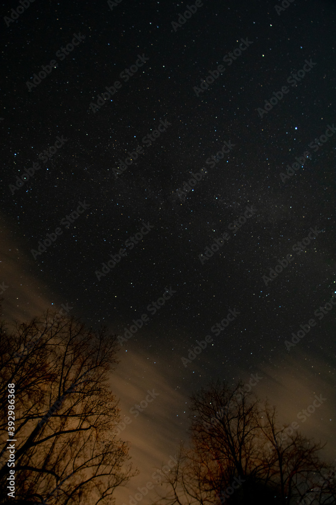 Fototapeta premium A Night Sky Full of Stars and Orange Clouds