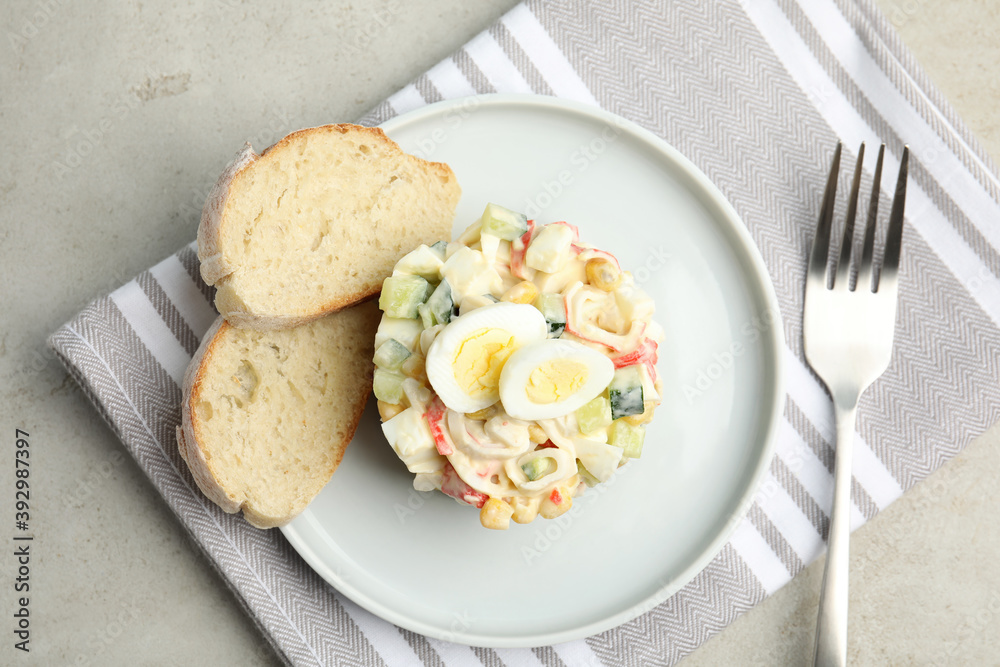 Delicious salad with crab sticks and eggs served on grey table, flat lay