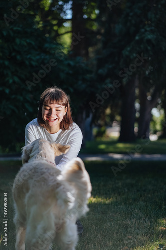 Wallpaper Mural Beautiful woman with playful young dog on fresh green meadow Torontodigital.ca