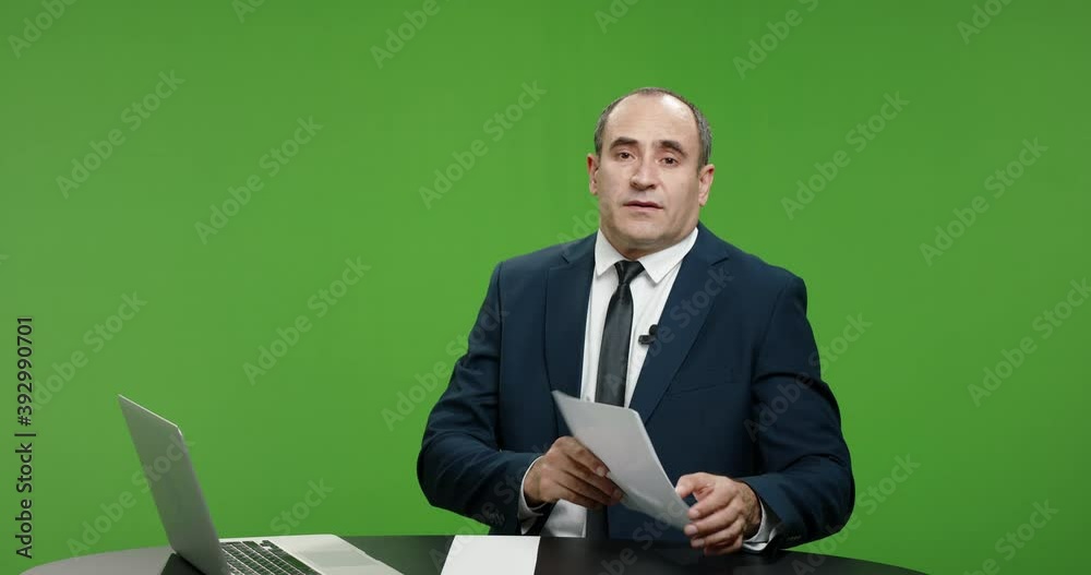 Male television anchor is talking about current news. Serious professional tv channel broadcast news reporter looking at camera. Green background chroma key template 4k footage Male television anchor is talking about current news. Serious professional tv channel broadcast news reporter looking at camera. Green background chroma key template 4k footage