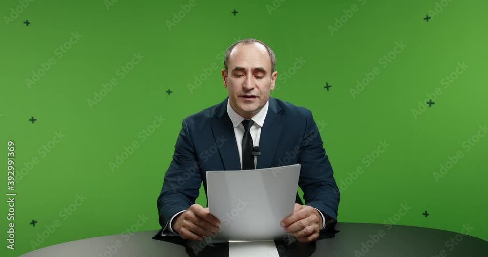 Male television anchor frustrated with script, standing up and walking away. News reporter angry with gutter press and fake news, shot on green chroma key background 4k footage