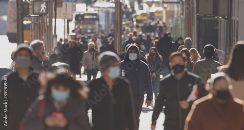 Obraz na płótnie Crowd of people walking street wearing masks