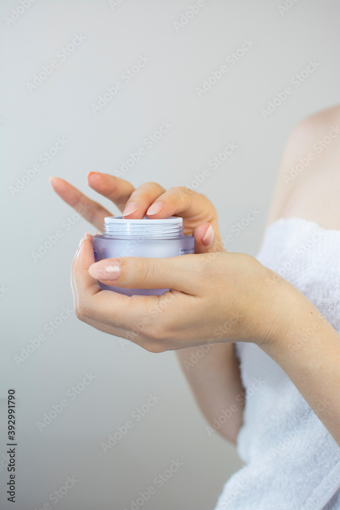 Woman's hands holding a bottle of cream to apply to her face
Woman's hands holding a bottle of cream to apply to her face