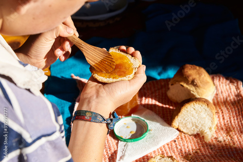 Mano de niño untando mermelada casera con cuchara sobre en pan casero