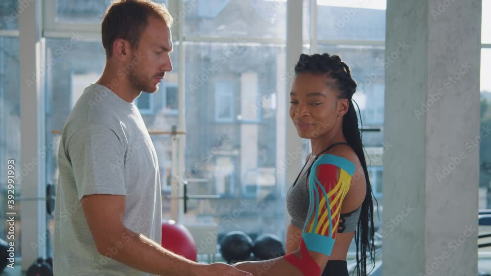 Tapes are help you. Trainer and african american woman athlete. Coach