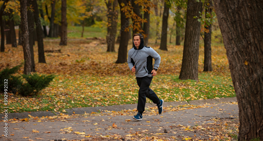 Fototapeta premium Man jogging in the autumn park