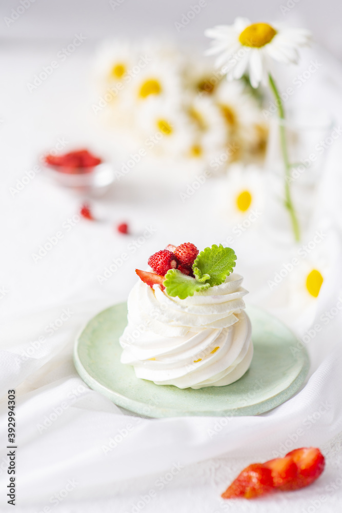 Meringue and whipped cream cake decorated with strawberries and mint on the table Meringue and whipped cream cake decorated with strawberries and mint on the table
