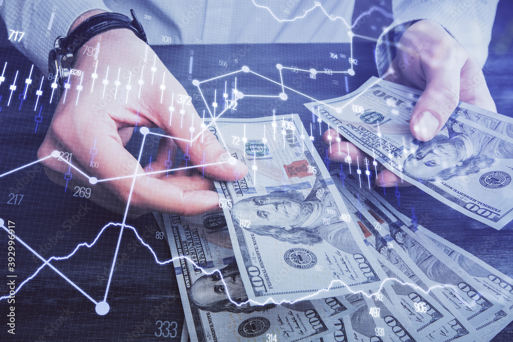 Multi exposure of financial graph drawing hologram and USA dollars bills and man hands. Analysis concept.