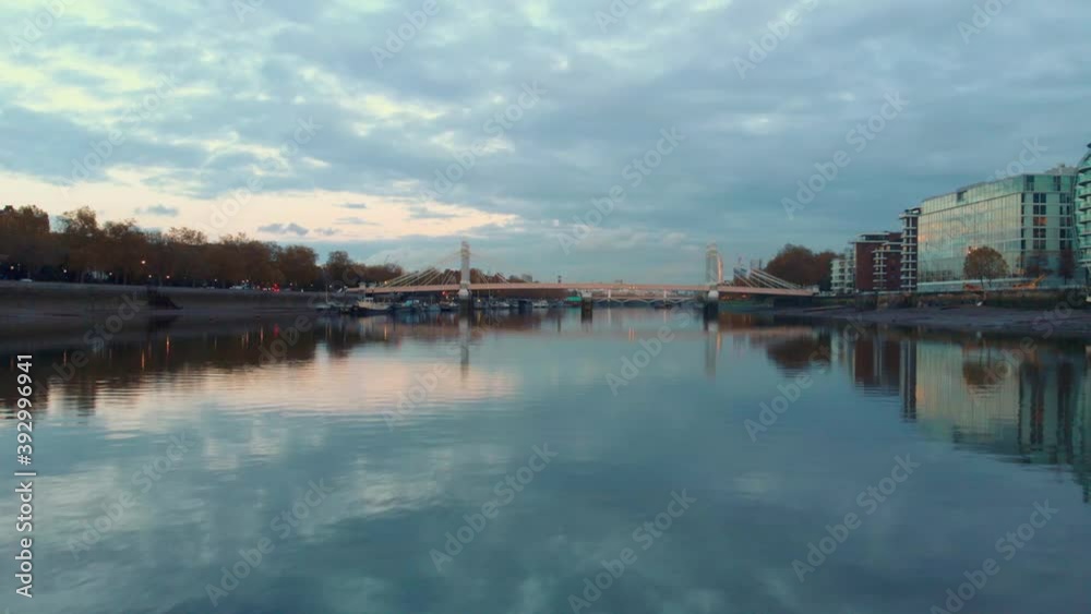 dolly forward rising reveal drone shot of Albert bridge and London city at sunset dolly forward rising reveal drone shot of Albert bridge and London city at sunset
