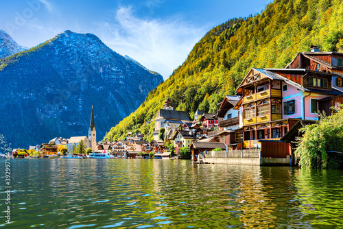 Scenic panoramic view of famous Hallstatt lakeside town reflecting in Hallstättersee lake in the Austrian Alps in scenic light on a beautiful sunny day in autumn, Salzkammergut region, Austria