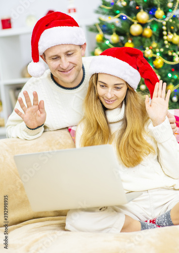 Cute family saying hello to some relatives while doing a video call on Christmas Eve