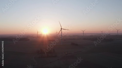 Sun just after sunrise behind wind turbine farm. photo