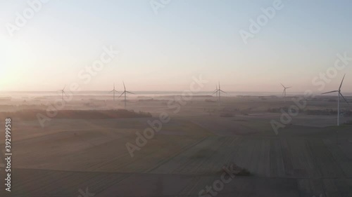 foggy sunrise over wind farm in mazowia, Poland. Drone footage. photo