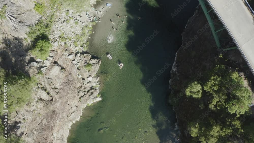 Drone shot from above of people playing in a blue green river Drone shot from above of people playing in a blue green river