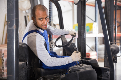 Latin American male operator of forklift working in building materials hypermarket