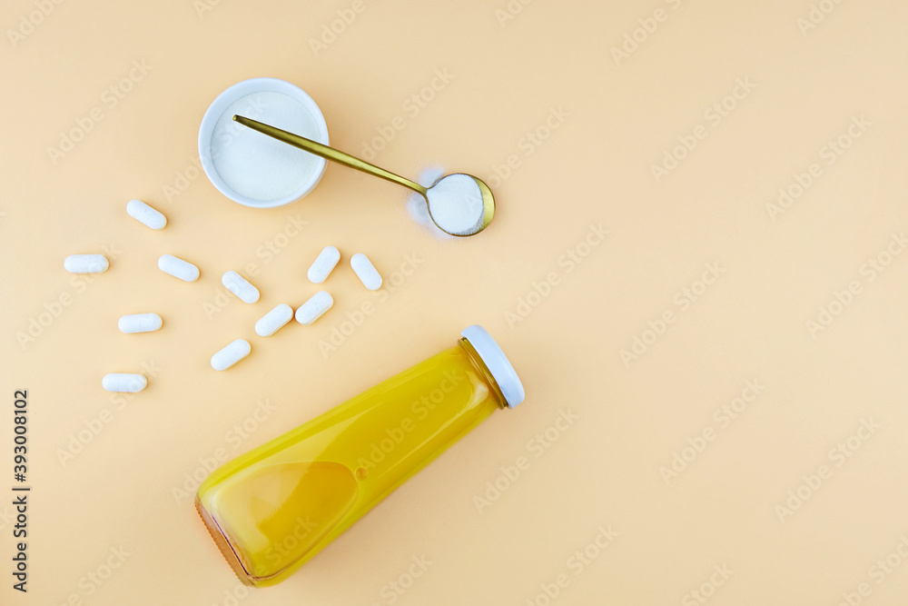 Collagen protein powder and pills, a bottle of orange juice. Dietary supplement for skin and joints. Collagen protein powder and pills, a bottle of orange juice. Dietary supplement for skin and joints.