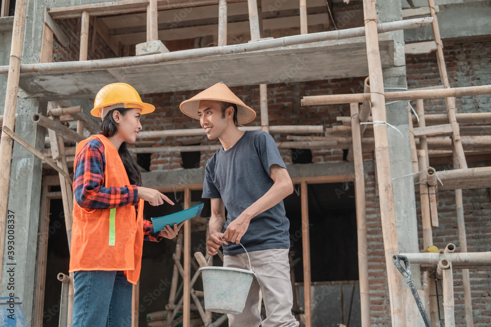 contractor and builder discussion about building sketches in the building construction background contractor and builder discussion about building sketches in the building construction background