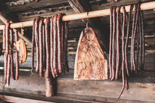 Smoked sausages and bacon hanging in row