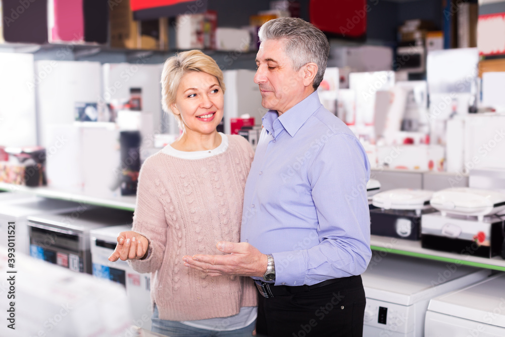 Obraz premium Married adults are visiting shop of household appliances for survey of goods for kitchen and house.