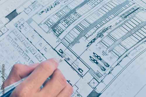 Close up hand write on paper blueprint checking building construction project