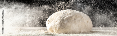 Tela yeast dough for bread or pizza on a floured surface, with flour splash