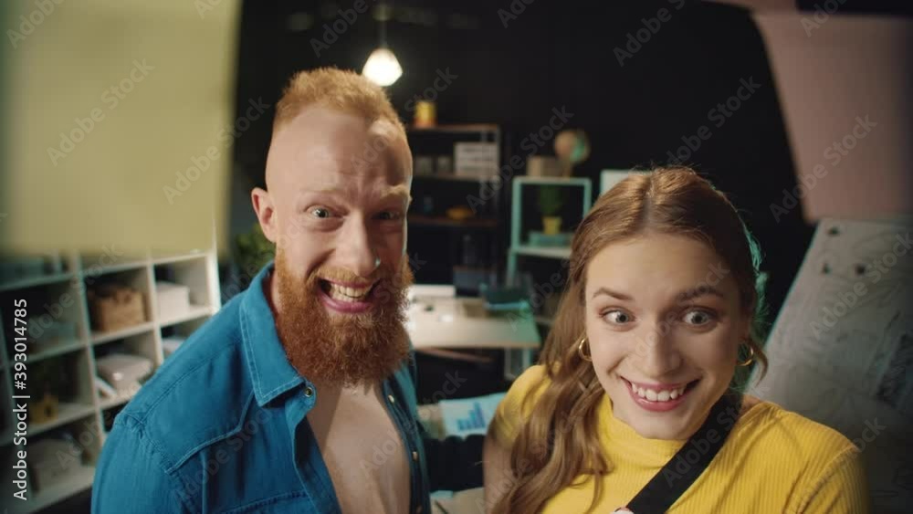Happy hipster man and woman giving five near board with notes in workplace. Happy hipster man and woman giving five near board with notes in workplace.