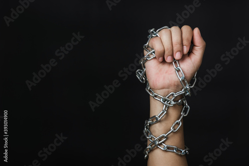 Woman chained on hand on black background, Human trafficking and abuse, International Human Rights day
