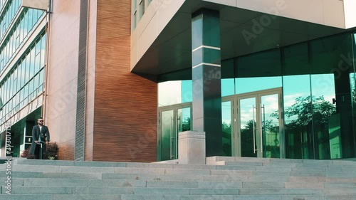 Full stab shot of male office worker arriving to modern office using electric scooter parking near office exterior entrance