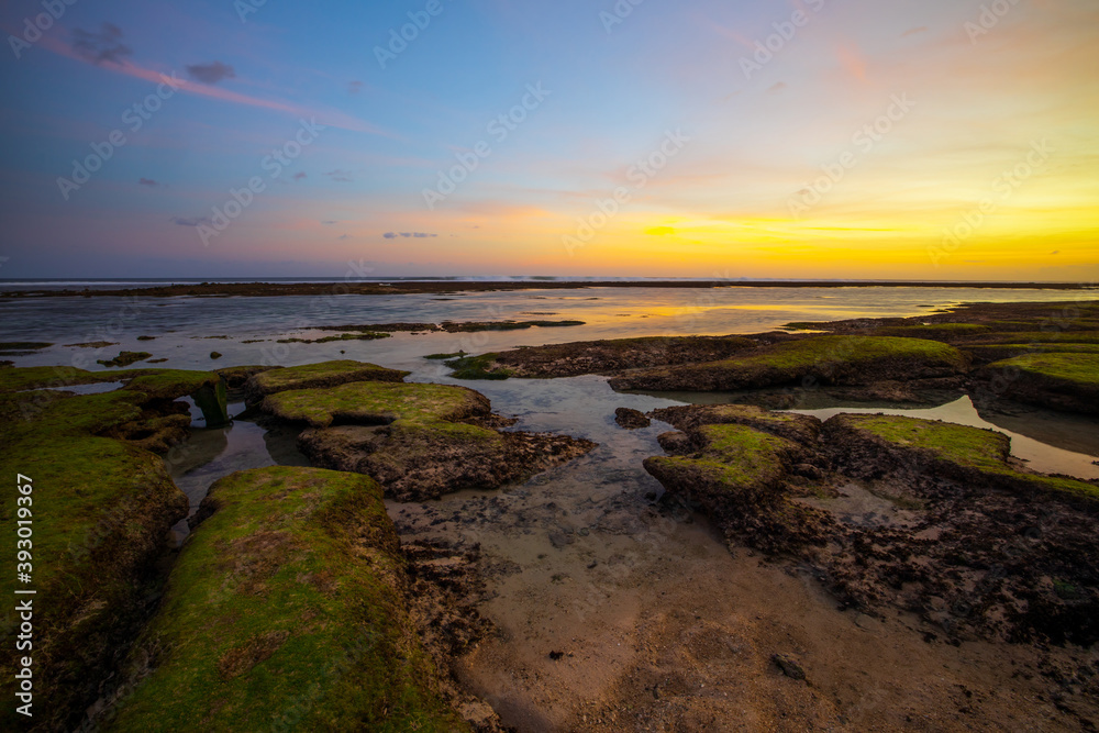 Seascape. Beach with rocks and stones. Low tide. Sunset time. Slow shutter speed. Soft focus. Melasti beach, Bali, Indonesia Seascape. Beach with rocks and stones. Low tide. Sunset time. Slow shutter speed. Soft focus. Melasti beach, Bali, Indonesia