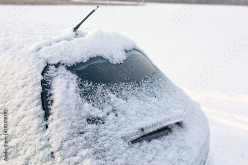 rear window of car is strewn with fresh snow.