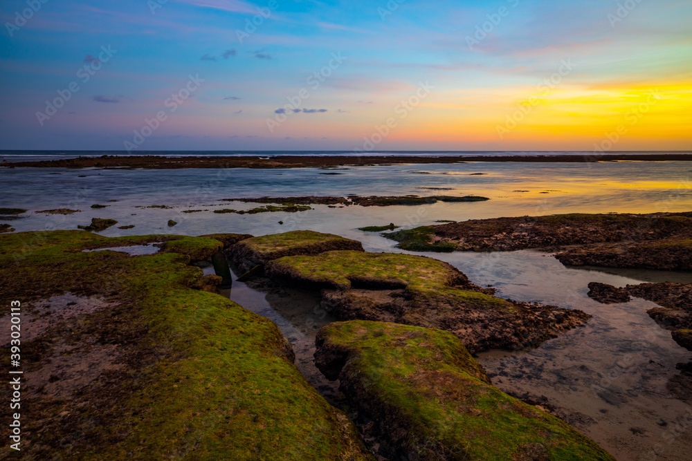 Seascape. Beach with rocks and stones. Low tide. Sunset time. Slow shutter speed. Soft focus. Melasti beach, Bali, Indonesia Seascape. Beach with rocks and stones. Low tide. Sunset time. Slow shutter speed. Soft focus. Melasti beach, Bali, Indonesia