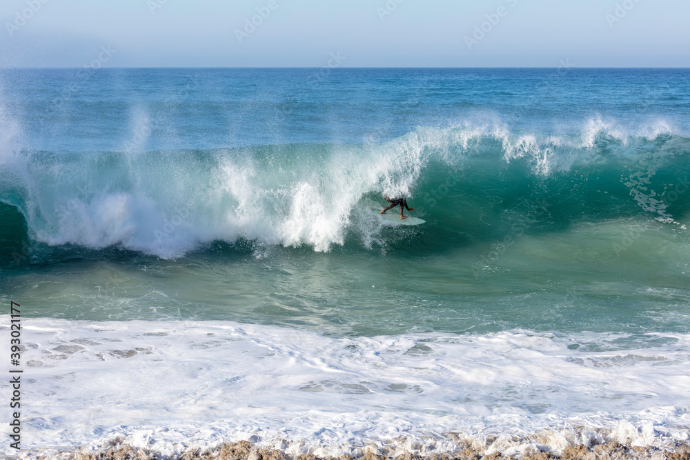 Fototapeta premium wave breaking on the beach with surfer