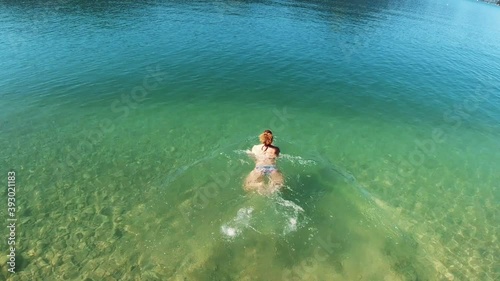A woman plunges into the clear alpine lake Wolfgangsee