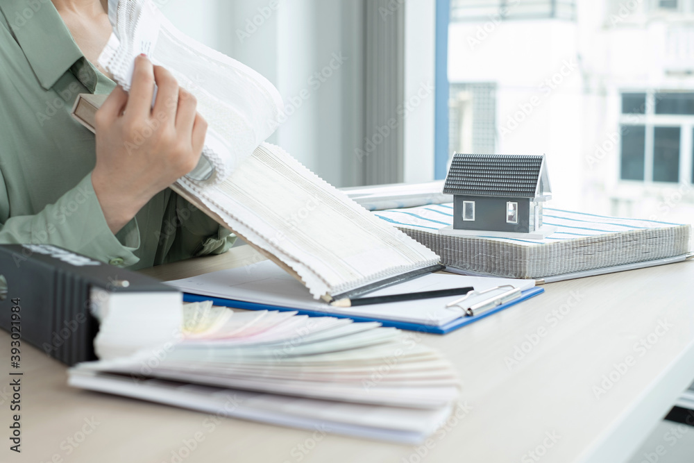 The designer is planning the interior of the house, illustrating and choosing the perfect colors for the new home with sample materials on the desk. Real estate design business Ideas