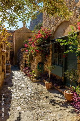 Fototapeta Naklejka Na Ścianę i Meble -  Traditional architecture with  narrow  stone street and a colorfull bougainvillea in  the medieval  castle of Monemvasia, Lakonia, Peloponnese, Greece.