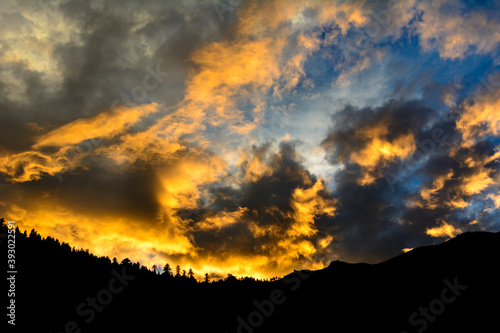 Sun reflected clouds in the sky and silhouette of mountains of Himalaya