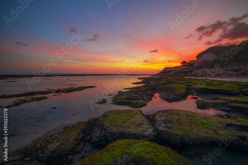 Seascape. Beach with rocks and stones. Low tide. Pink sunset. Slow shutter speed. Soft focus. Melasti beach  Bali  Indonesia